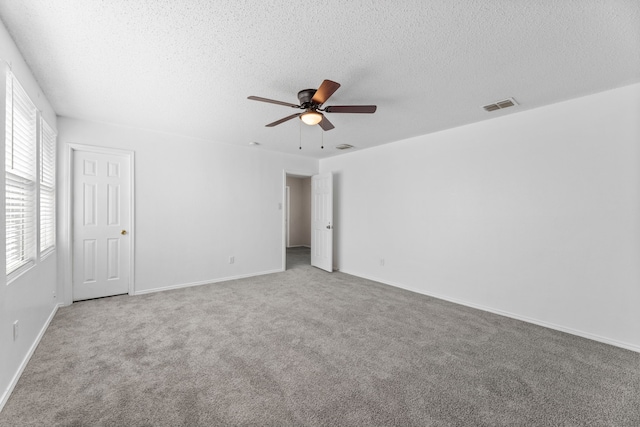 unfurnished bedroom featuring carpet, a textured ceiling, a ceiling fan, and baseboards