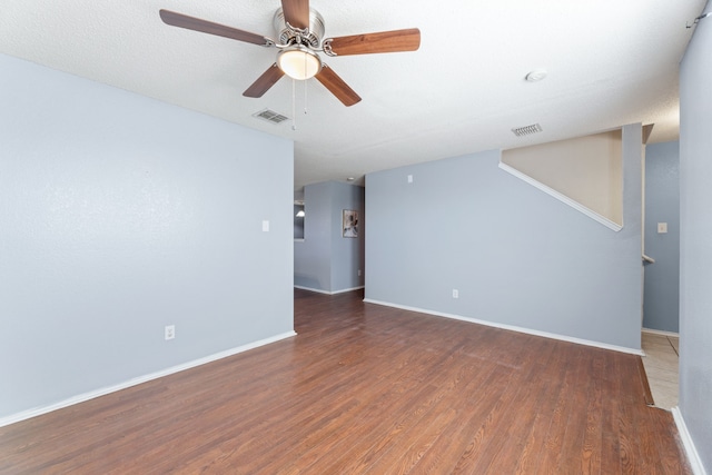 empty room with wood finished floors, baseboards, and ceiling fan