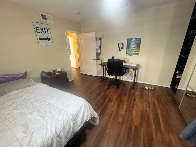 bedroom featuring baseboards, visible vents, and wood finished floors