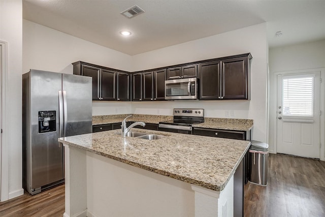 6214 Old Bridge Way, Forney, TX 75126 - kitchen with light stone countertops, appliances with stainless steel finishes, a sink, dark wood finished floors, and visible vents