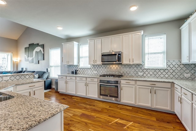 905 Bird Creek Dr, Little Elm, TX 75068 - kitchen featuring appliances with stainless steel finishes, open floor plan, white cabinetry, wood finished floors, and recessed lighting