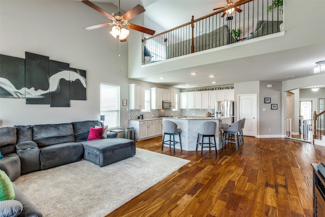 905 Bird Creek Dr, Little Elm, TX 75068 - living area with a ceiling fan, dark wood finished floors, arched walkways, a towering ceiling, and baseboards