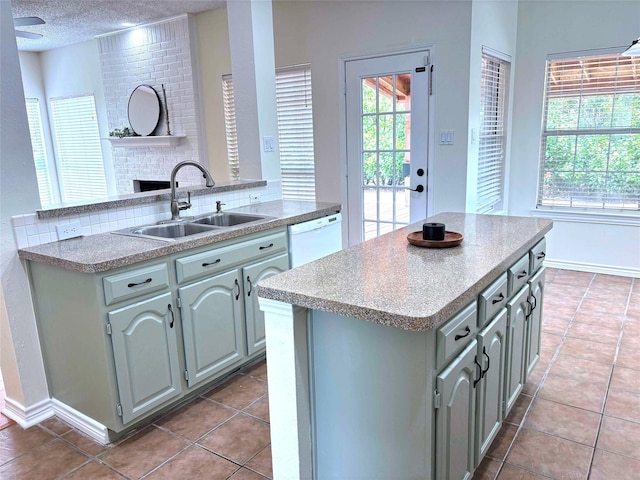 2212 Remmington Dr, Flower Mound, TX 75028 - kitchen with dishwasher, a sink, a fireplace, healthy amount of natural light, and a textured ceiling