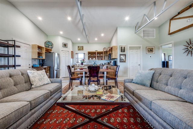 living area with visible vents, a high ceiling, and recessed lighting