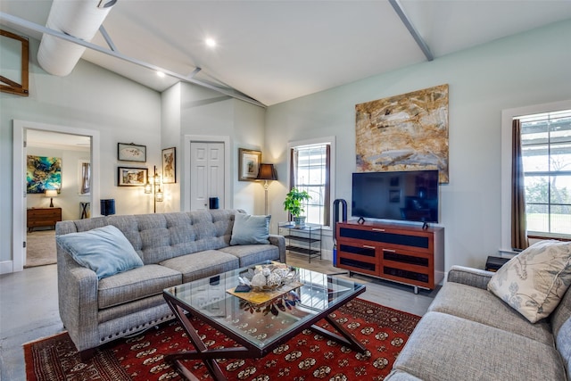 living room with a wealth of natural light, vaulted ceiling, and baseboards