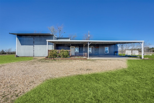 back of house with an attached carport, an outbuilding, and a lawn