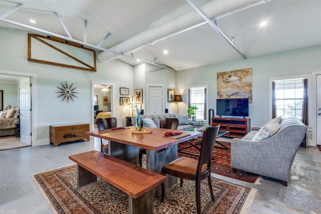 dining room with concrete flooring, high vaulted ceiling, baseboards, and recessed lighting