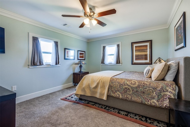 carpeted bedroom featuring baseboards, a ceiling fan, visible vents, and crown molding