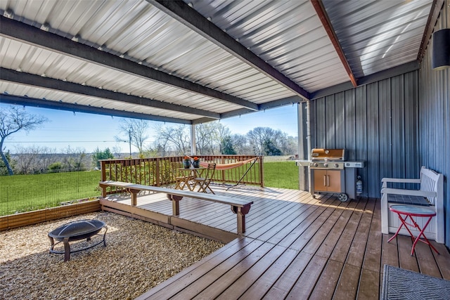 wooden deck with a fire pit and a lawn