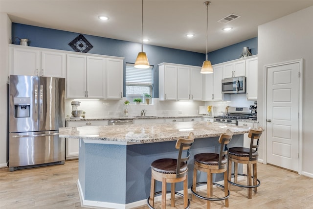 dining area with baseboards, visible vents, and light wood-style floors