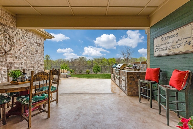 view of patio with exterior kitchen and fence