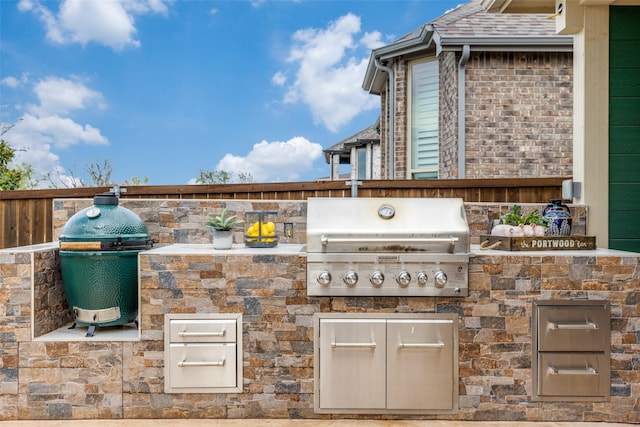 view of patio / terrace featuring an outdoor kitchen, fence, and grilling area