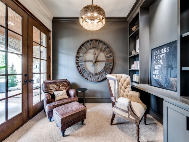 living area featuring a chandelier, built in features, baseboards, ornamental molding, and french doors