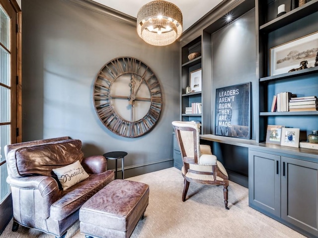 living area featuring an inviting chandelier, built in shelves, light carpet, built in study area, and baseboards