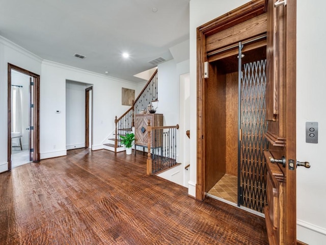 interior space with ornamental molding, visible vents, elevator, and baseboards