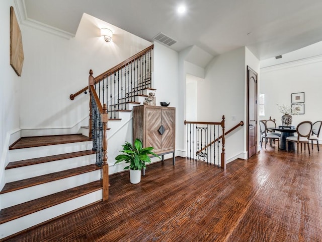 stairs featuring visible vents, wood finished floors, and baseboards