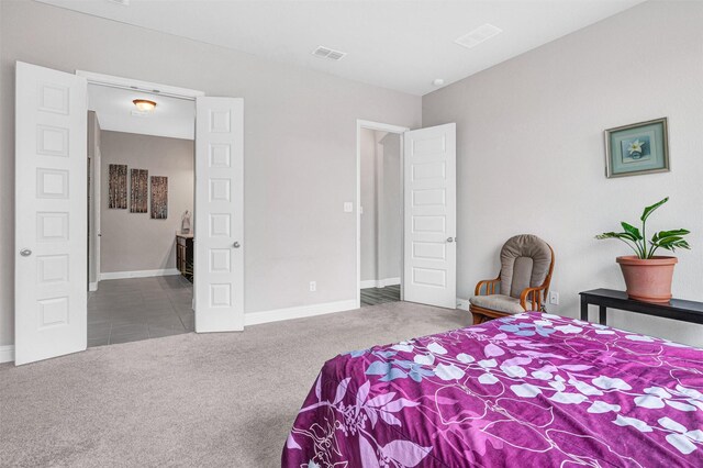 carpeted bedroom featuring baseboards and visible vents