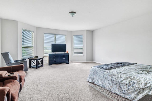 bedroom with light colored carpet and baseboards