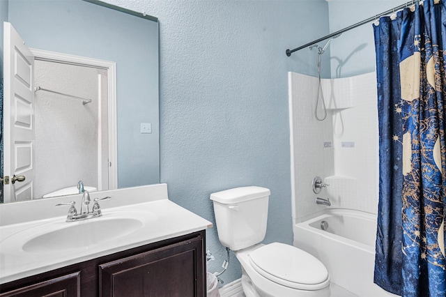 full bath featuring toilet, shower / bathtub combination with curtain, a textured wall, and vanity