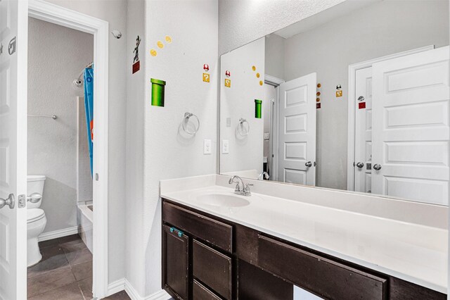 bathroom with tile patterned floors, shower / bath combo with shower curtain, toilet, vanity, and baseboards