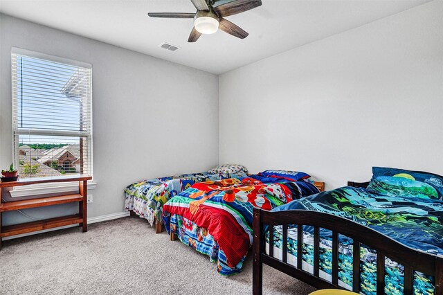 carpeted bedroom featuring visible vents, ceiling fan, and baseboards