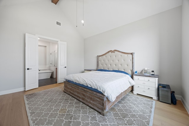 bedroom featuring baseboards, visible vents, high vaulted ceiling, and wood finished floors