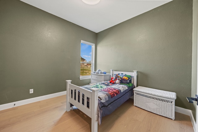 bedroom featuring baseboards and wood finished floors