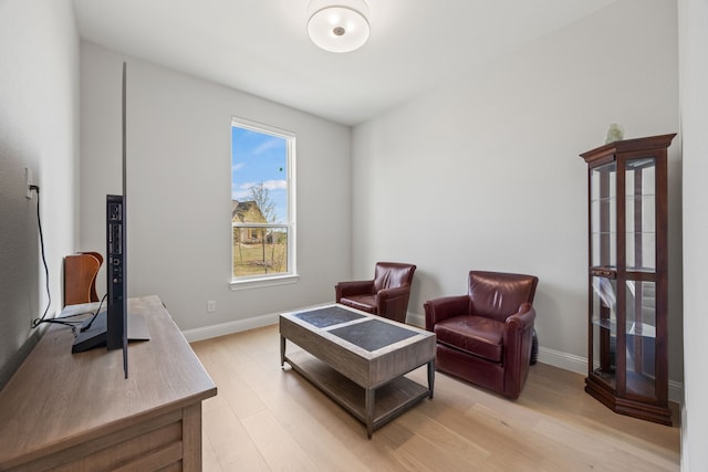 living area with baseboards and light wood finished floors