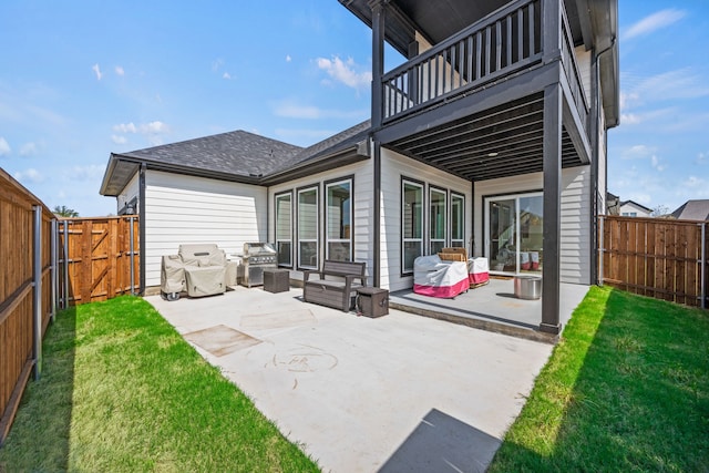 view of patio / terrace with a fenced backyard, a balcony, a gate, and a grill