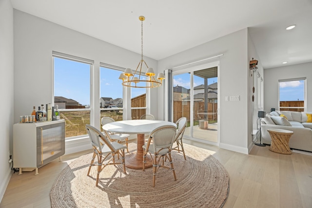 dining area featuring light wood finished floors, baseboards, recessed lighting, and a chandelier