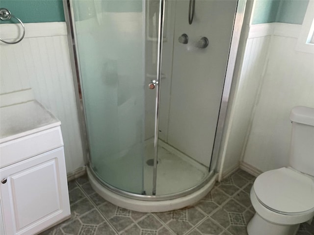 bathroom with a shower stall, tile patterned floors, toilet, and vanity