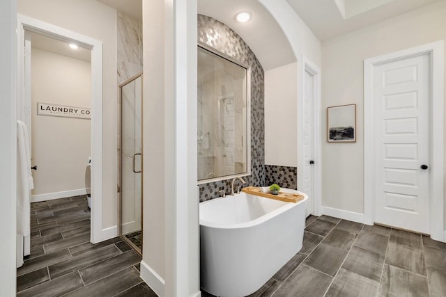 1030 Lone Grove Ln, Prosper, TX 75078 - bathroom featuring baseboards, wood tiled floor, a stall shower, and a soaking tub