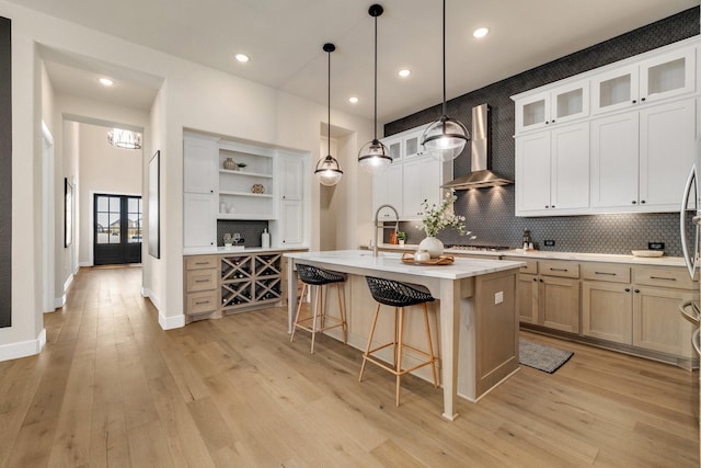 1030 Lone Grove Ln, Prosper, TX 75078 - kitchen featuring wall chimney range hood, a kitchen breakfast bar, backsplash, open shelves, and light countertops