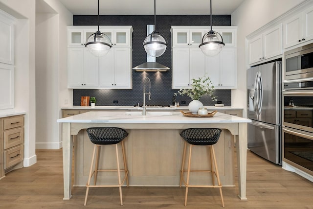 1030 Lone Grove Ln, Prosper, TX 75078 - kitchen featuring decorative backsplash, appliances with stainless steel finishes, a center island with sink, and a kitchen bar