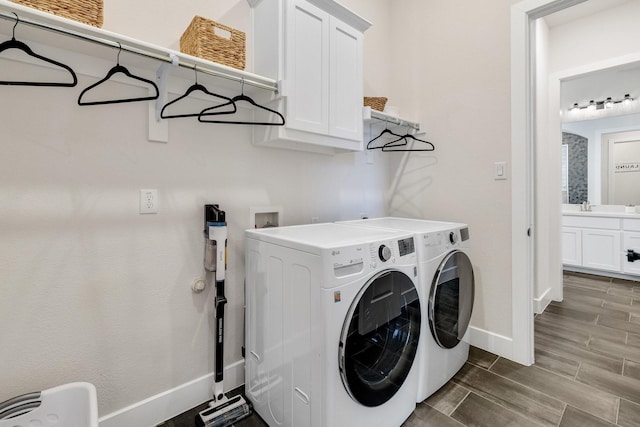 1030 Lone Grove Ln, Prosper, TX 75078 - laundry area with washing machine and dryer, baseboards, wood tiled floor, a sink, and cabinet space