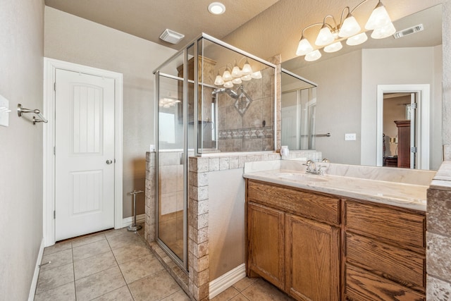 bathroom with vanity, tile patterned flooring, visible vents, a stall shower, and baseboards