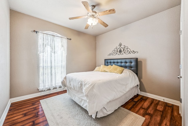 bedroom featuring dark wood-type flooring, ceiling fan, and baseboards