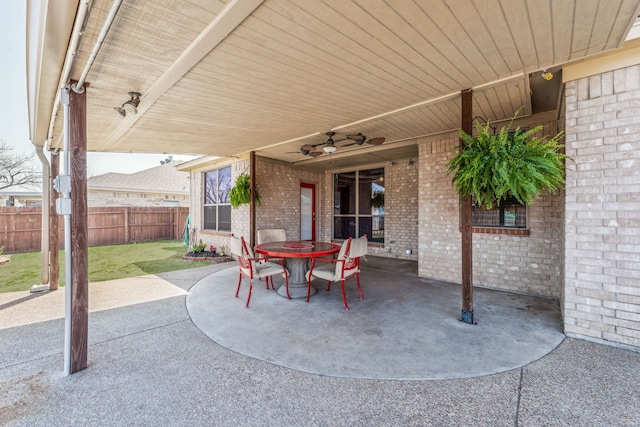 view of patio with outdoor dining area, fence, and ceiling fan