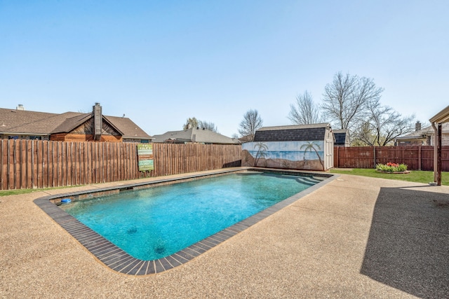 view of swimming pool with a shed, a fenced backyard, an outdoor structure, a patio area, and a fenced in pool