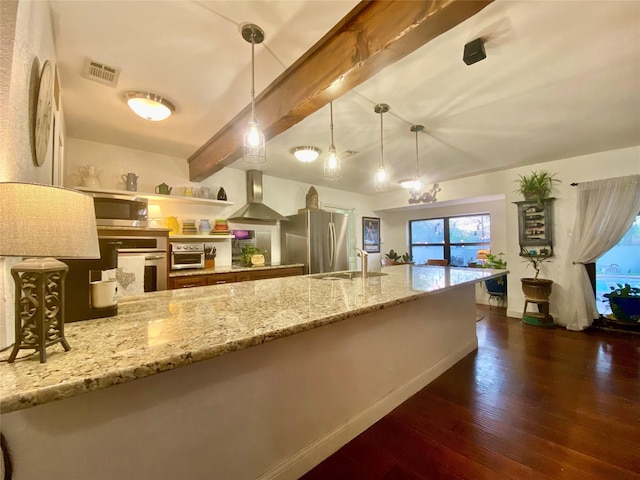 kitchen with dark wood finished floors, a sink, wall chimney exhaust hood, beam ceiling, and appliances with stainless steel finishes