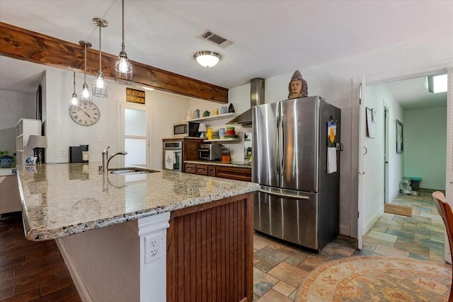 kitchen featuring wall chimney range hood, open shelves, a sink, stainless steel appliances, and a peninsula