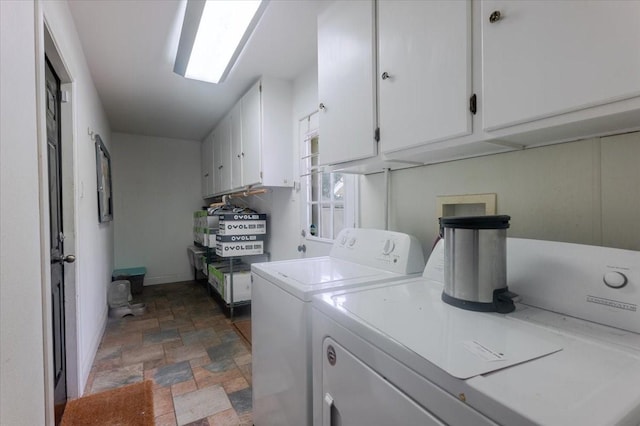 laundry area with cabinet space, stone finish floor, baseboards, and washer and dryer