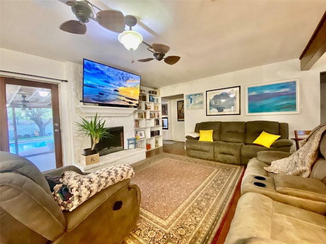 living room featuring a fireplace, built in shelves, and ceiling fan