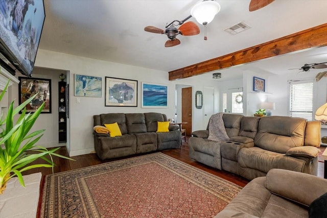 living area with wood finished floors, visible vents, a ceiling fan, and baseboards