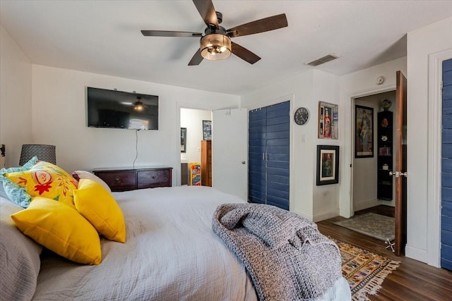 bedroom with wood finished floors, visible vents, baseboards, and ceiling fan
