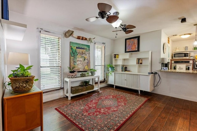 sitting room with hardwood / wood-style floors, baseboards, and ceiling fan
