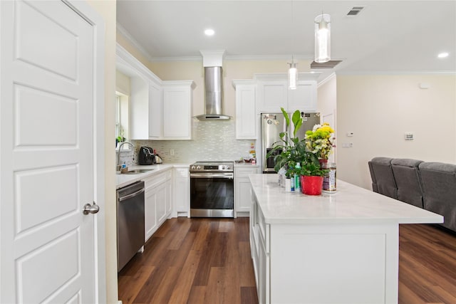 kitchen with a sink, wall chimney exhaust hood, a center island, stainless steel appliances, and visible vents