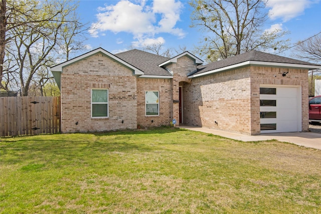 view of front of property with an attached garage, fence, brick siding, and a front yard