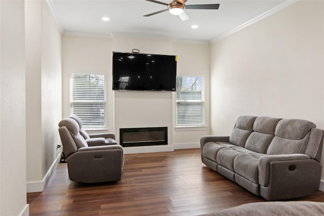 living room featuring wood finished floors, ornamental molding, baseboards, and ceiling fan