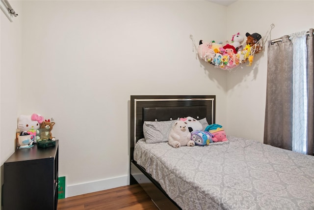 bedroom featuring baseboards and wood finished floors